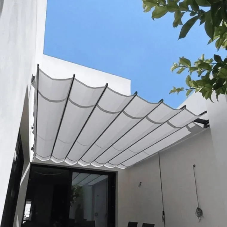 Toldo de palillería blanco fabricado por Tapisol desplegado sobre el patio de una vivienda