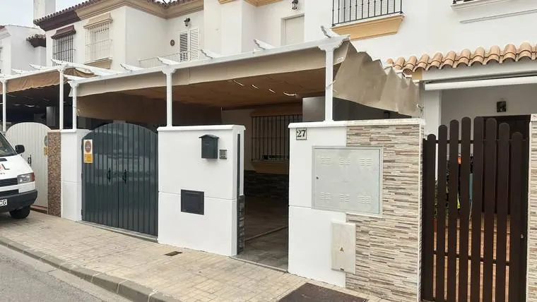 La misma casa desde la calle, con la estructura blanca y el toldo montado