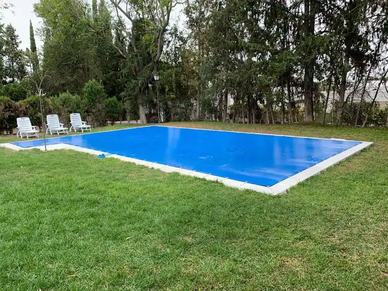 Lona azul de cubrición confeccionada a medida sobre una piscina particular